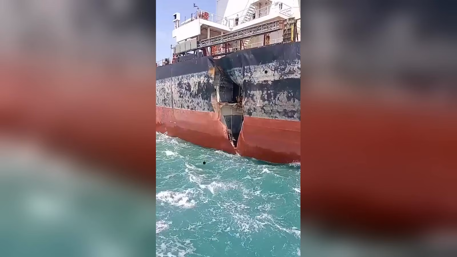 Siyah üst gövdeli, kırmızı alt gövdeli geminin yan tarafında, su hattına yakın büyük bir yırtık ve delik; turkuaz deniz.