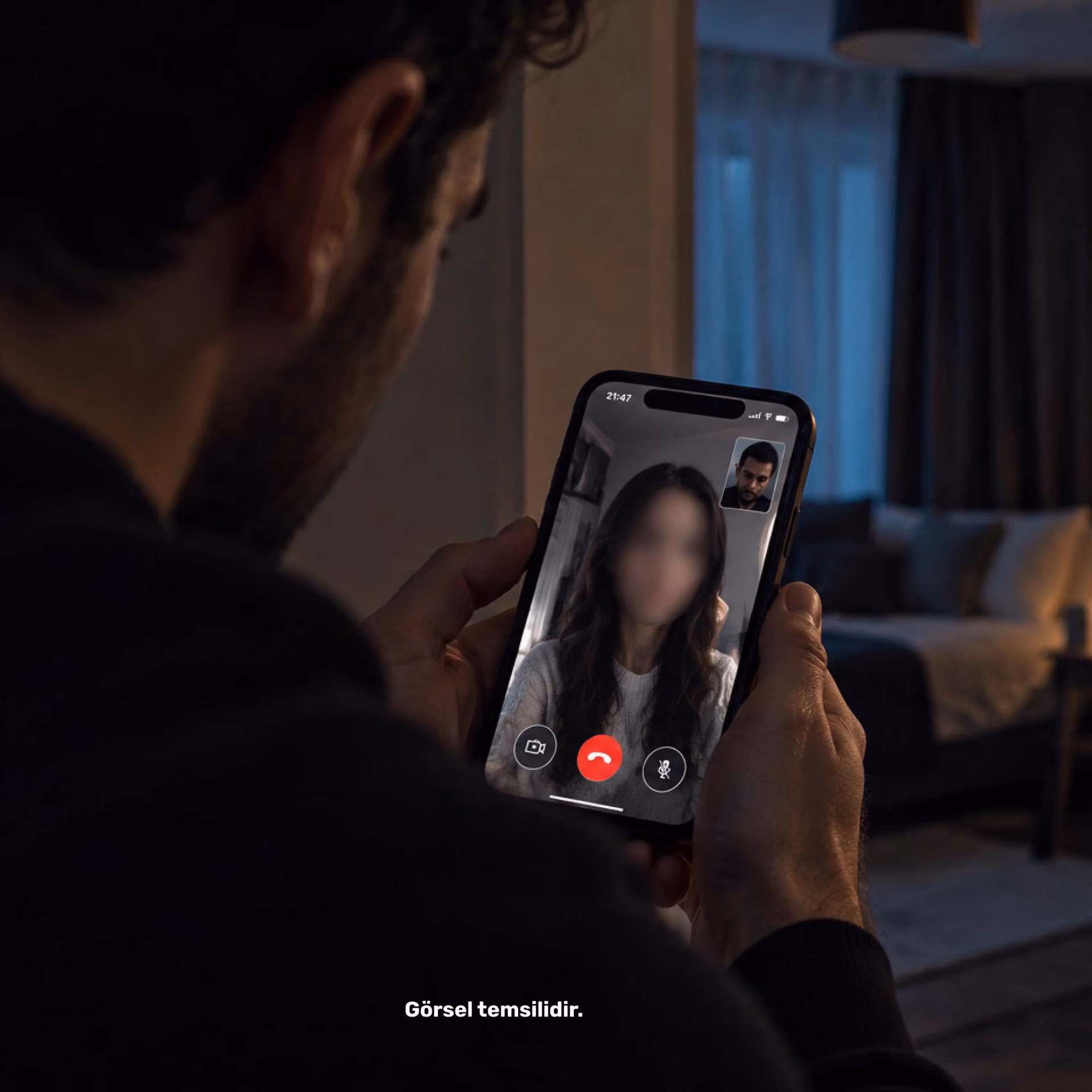 Elinde telefon tutan bir adamın görüntülü arama ekranı; karşıdaki kadının yüzü bulanık, köşede adamın küçük görüntüsü var.